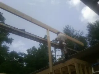 Carpenter setting a ridge beam over a new addition frame — Ice Dam Removal by Roofing Brothers in Ocean View